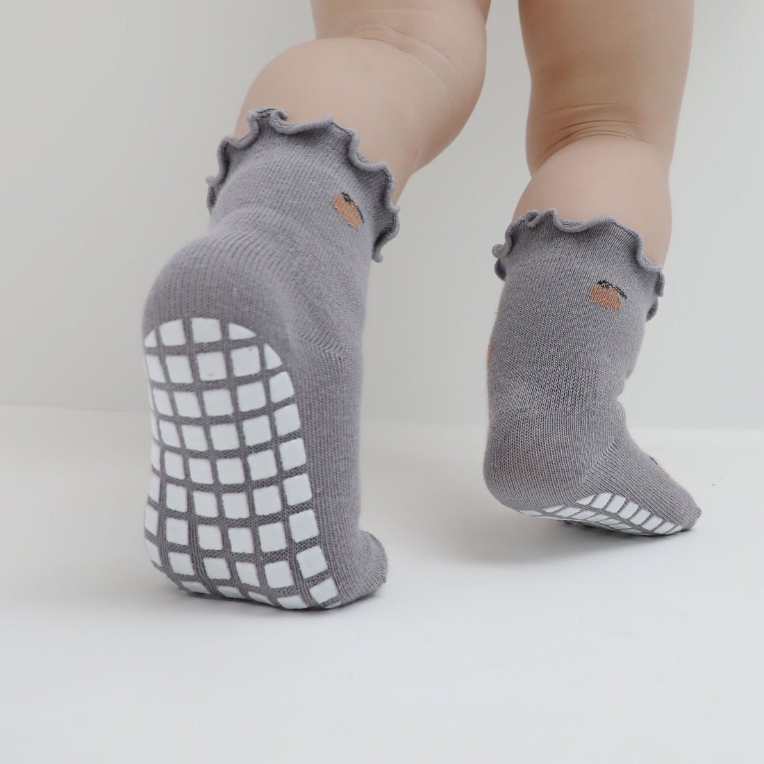 How do grip socks help in a baby's overall mobility and stability?