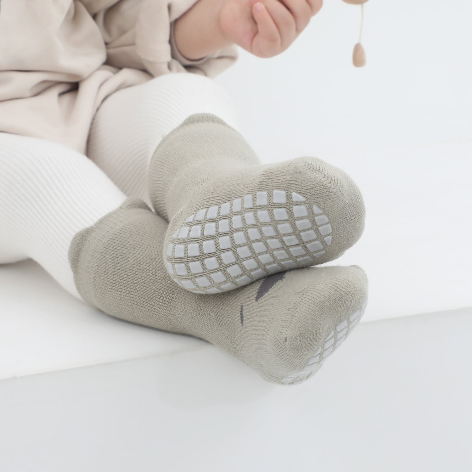 Infant grip socks blending safety with fun, designed for a sleek, minimalist look.